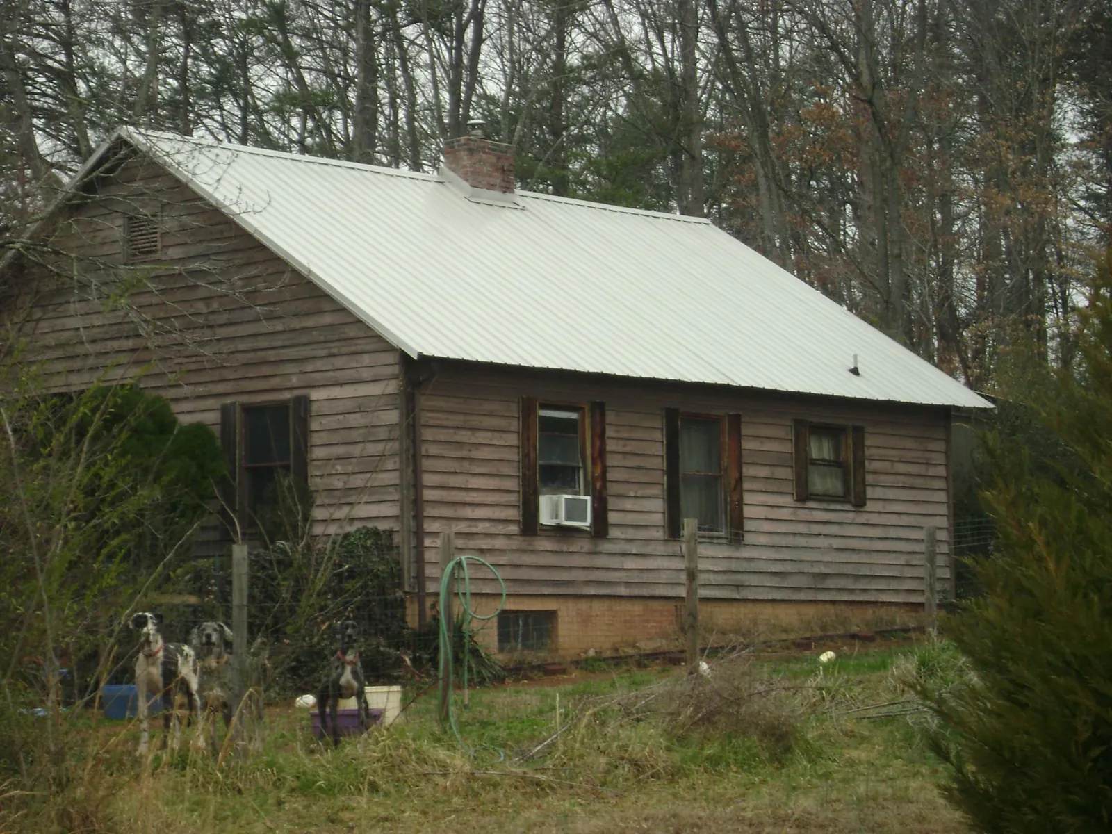 White metal roof on an old wood sided farmhouse, from a Metal Roof Installation job in Manton